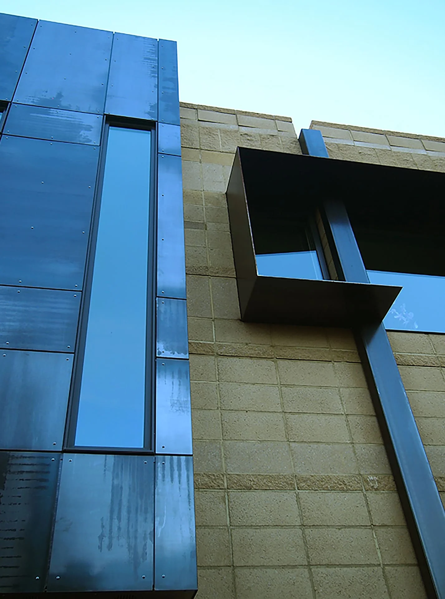 Tall zinc panel and steel box window set into a block wall