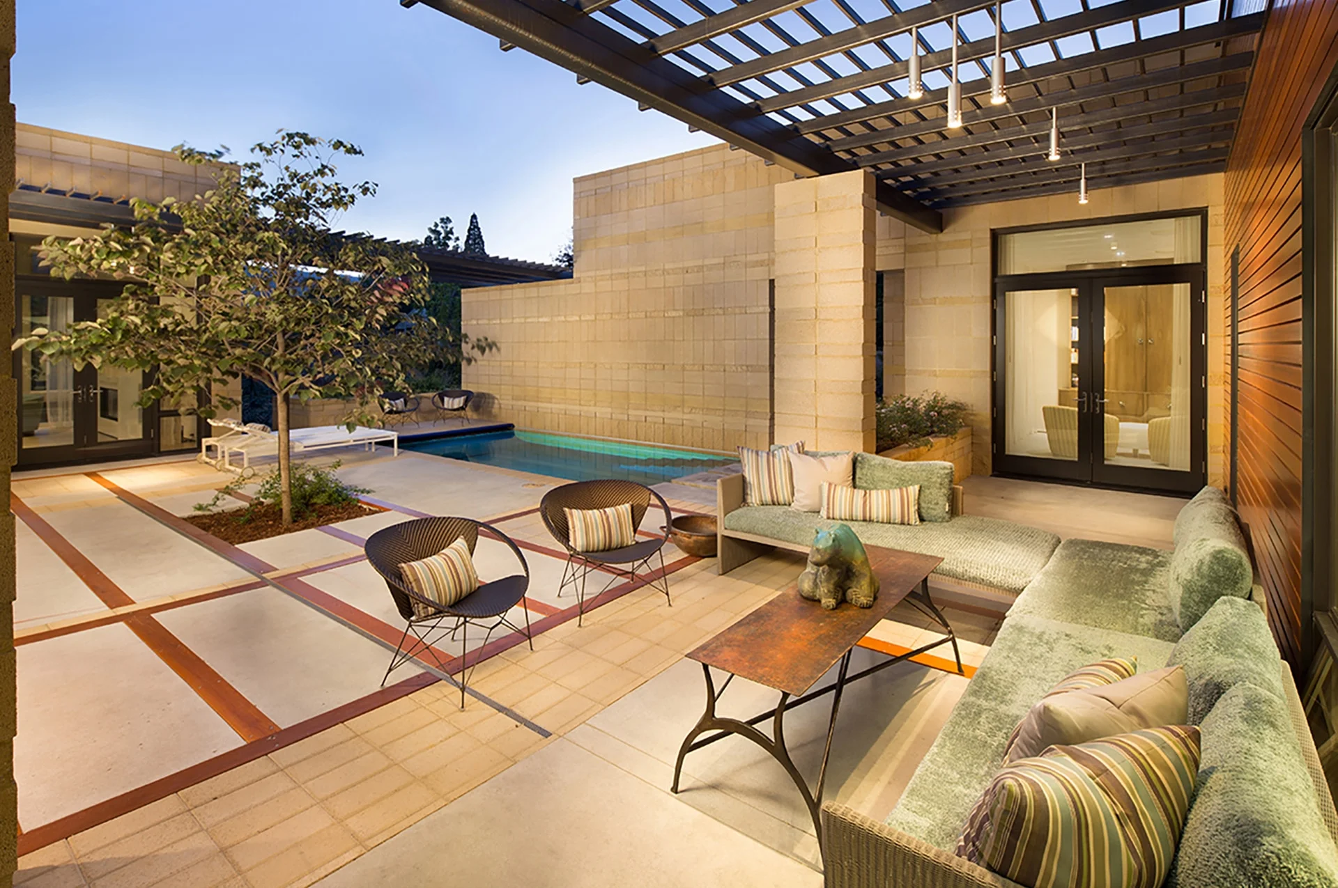 Patio seating under a trellis beside the pool