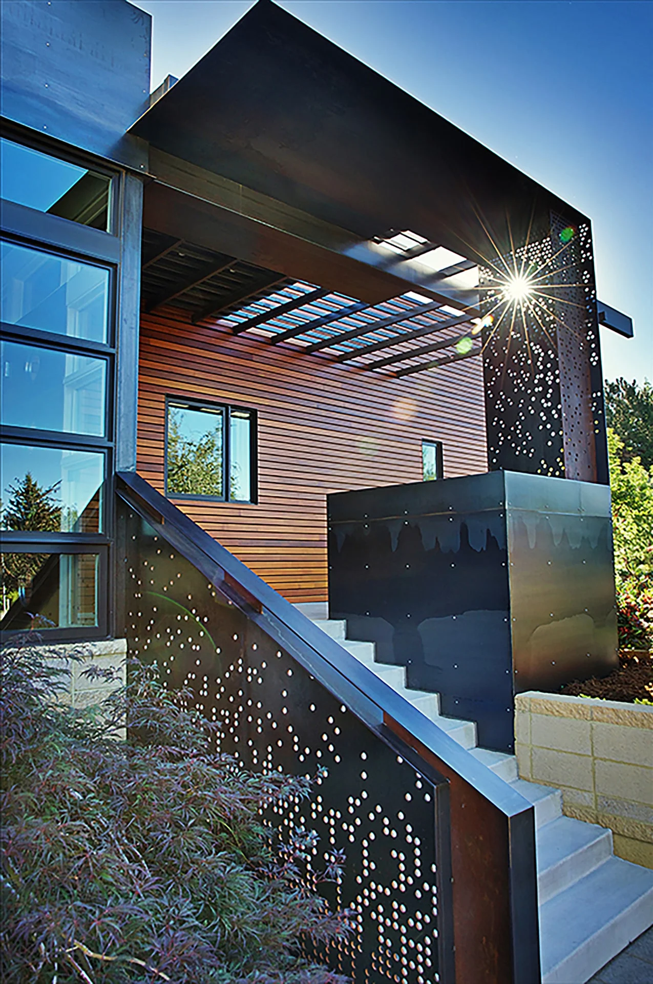 Exterior stair with perforated steel guardrail and cedar-clad volume