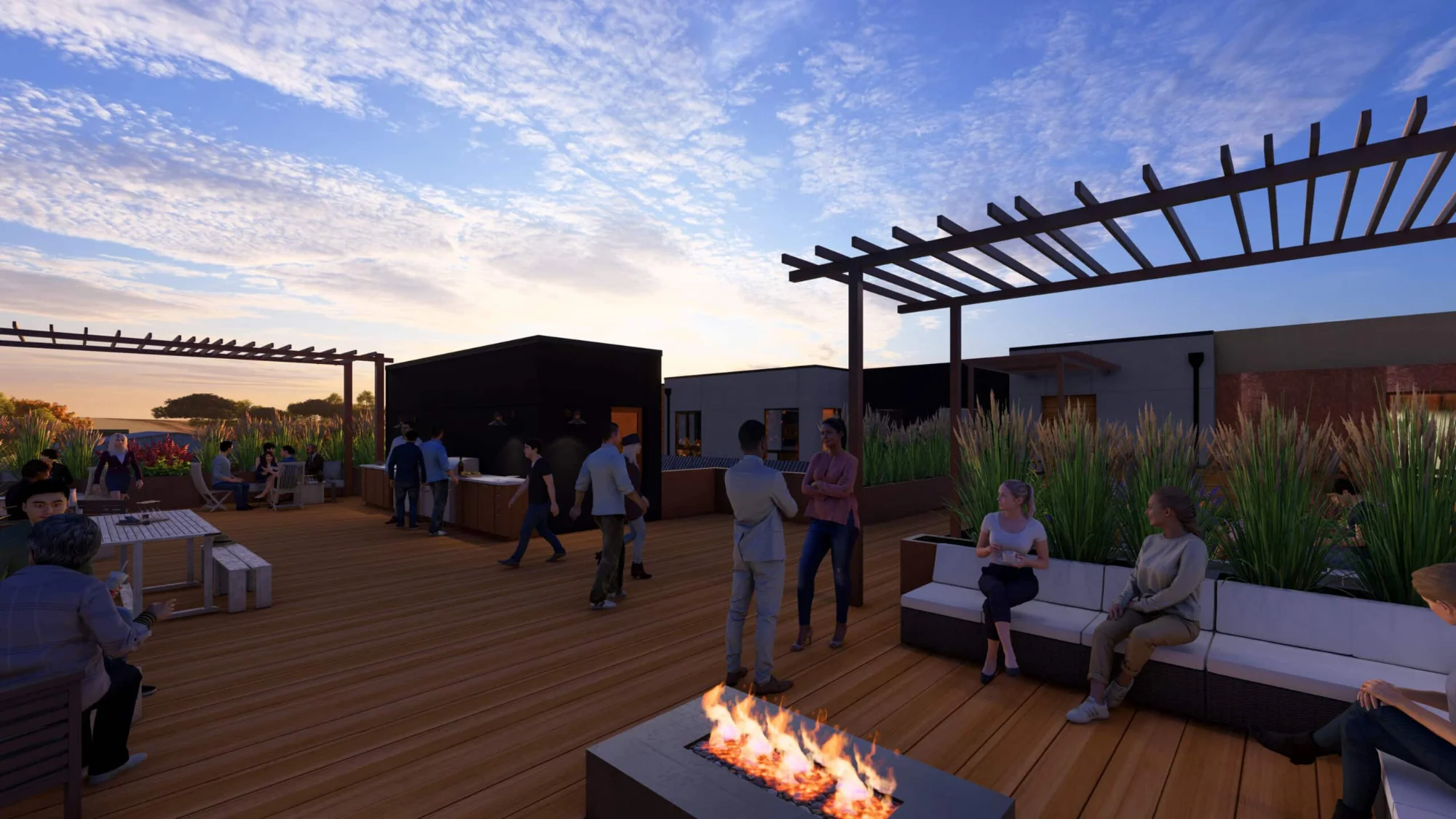 Rooftop lounge with a fire pit and city views at sunset