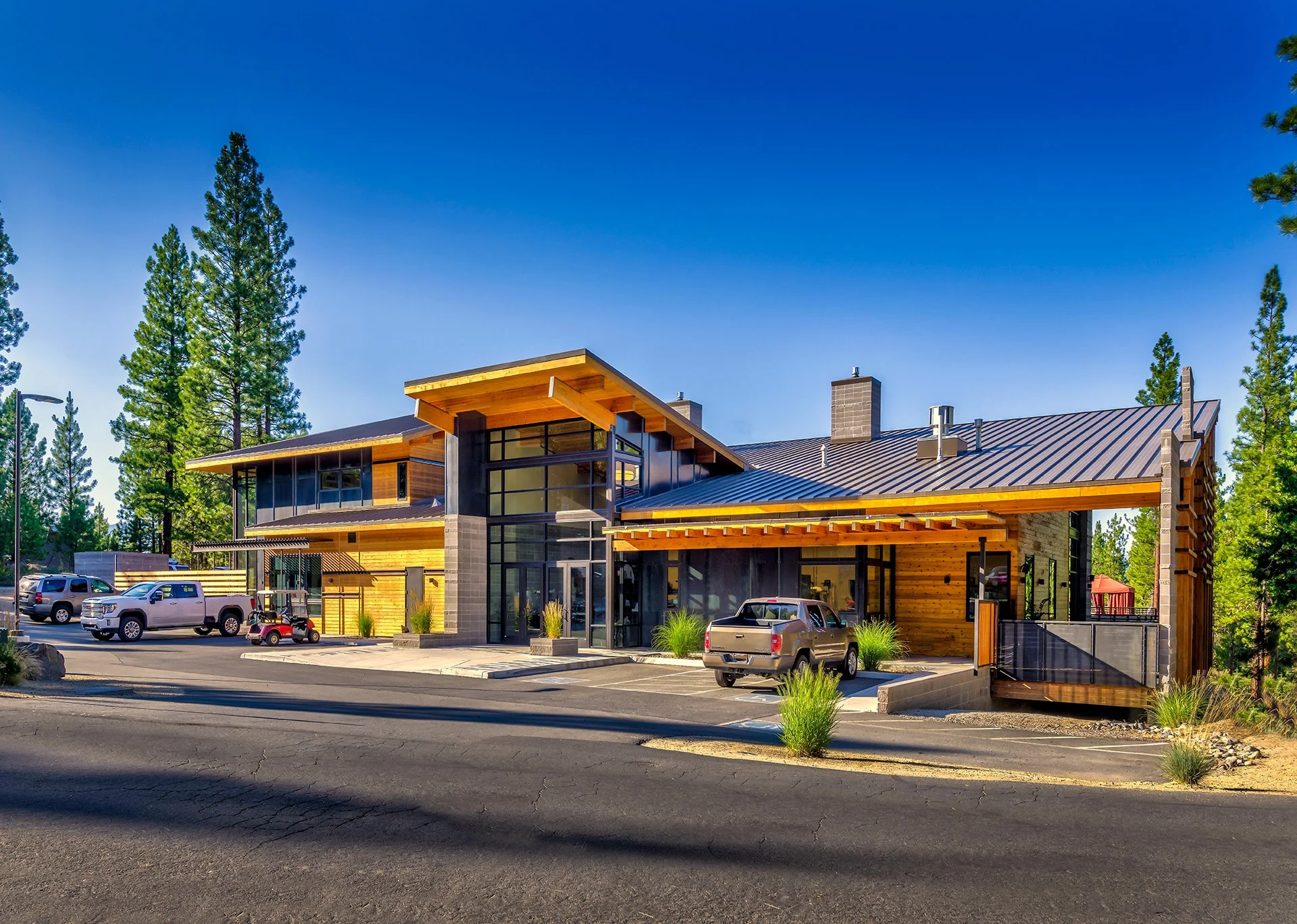Altitude entry with upswept timber roofs, stone and glass, and the drop-off drive