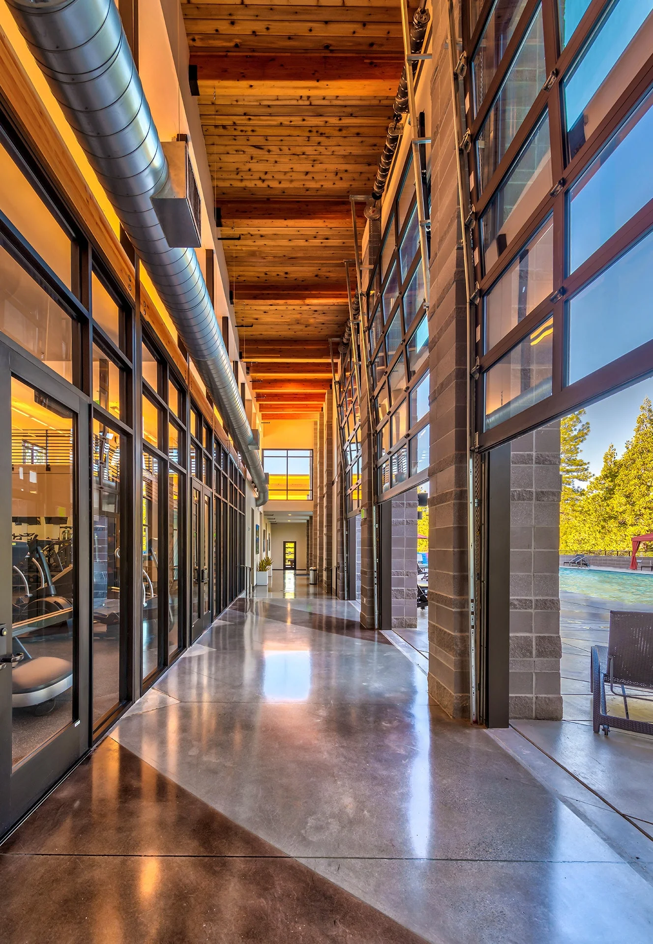 Long glass breezeway with polished concrete floor and wood ceiling