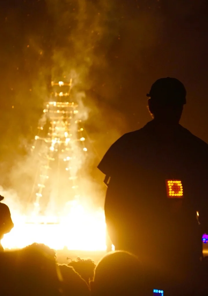 A figure silhouetted against the Man as it burns