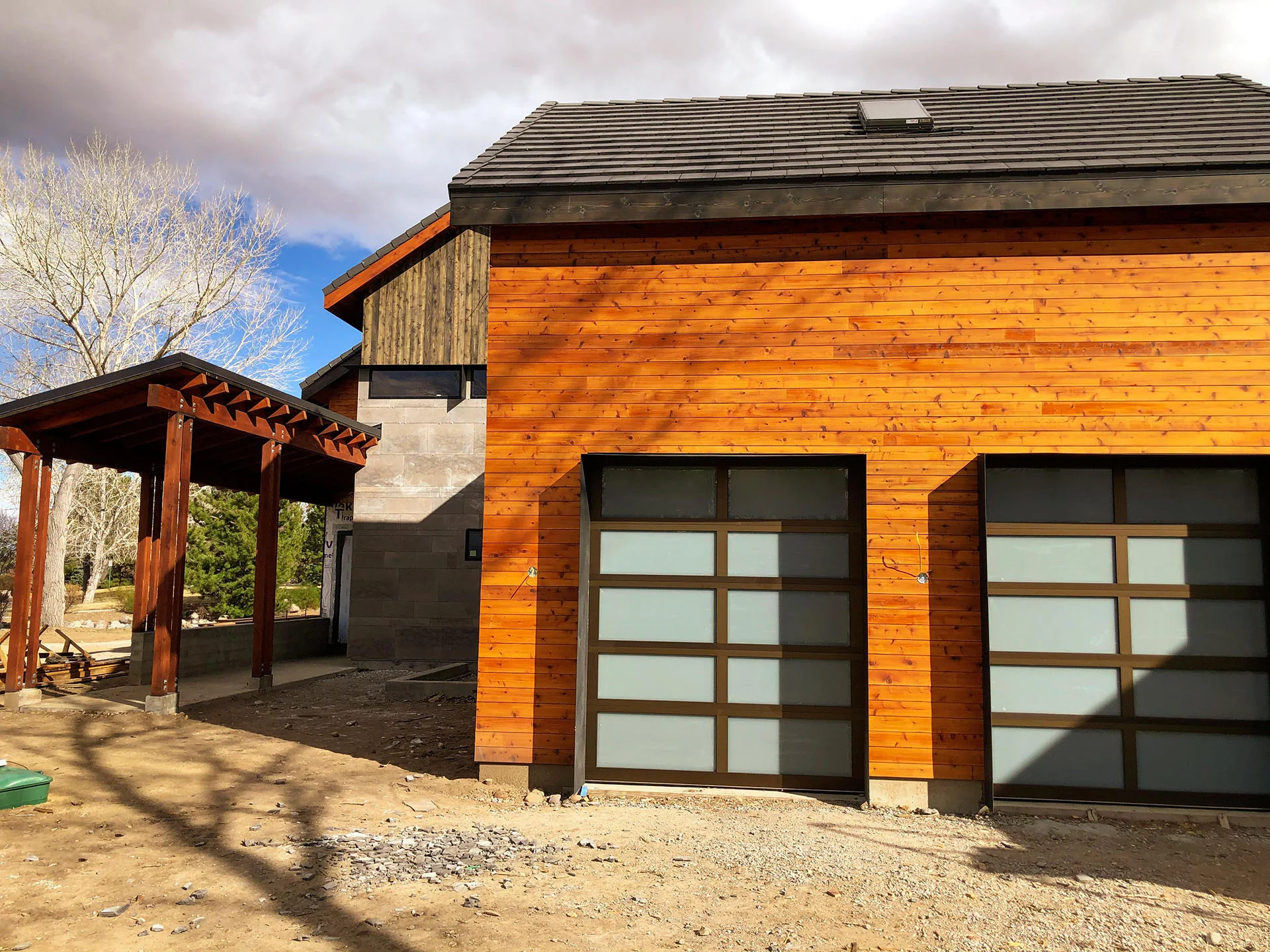 Garage wing with cedar siding and stone