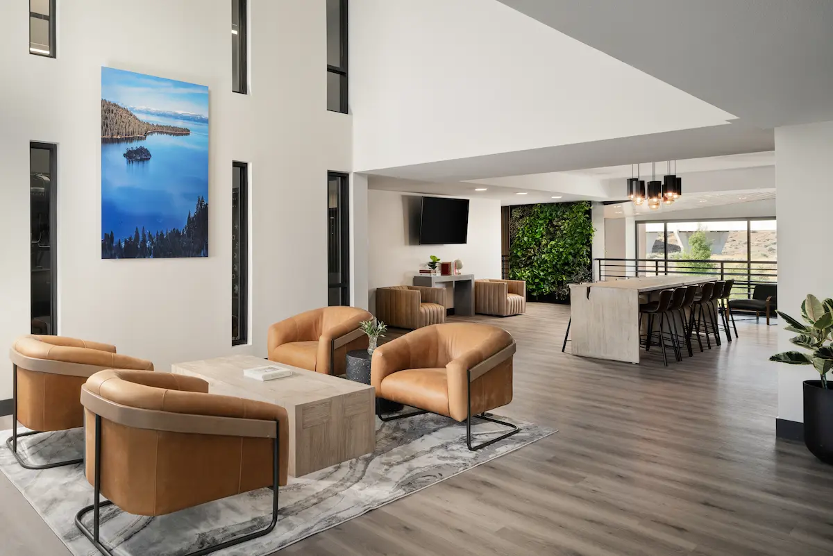 Double-height resident lounge with leather chairs and large blue artwork