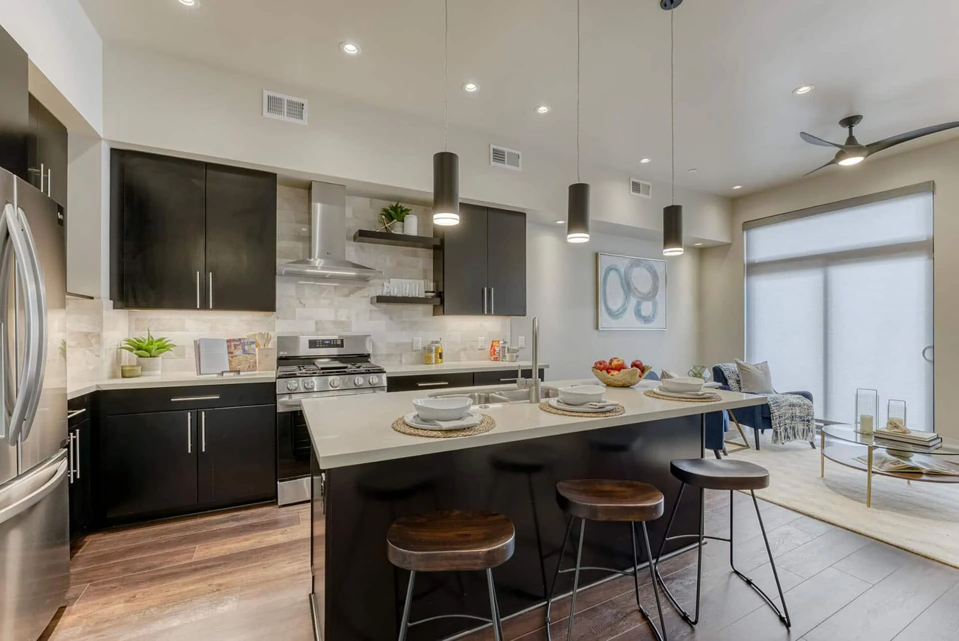 Kitchen with dark cabinets, a large island, and pendant lights