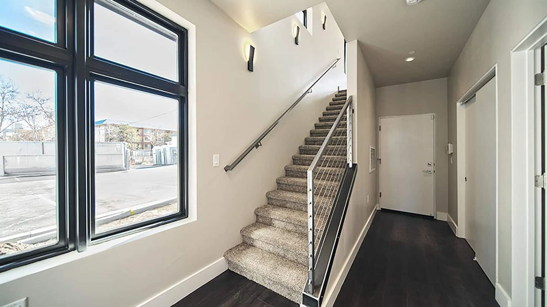 Stair and entry hall with tall black-framed windows