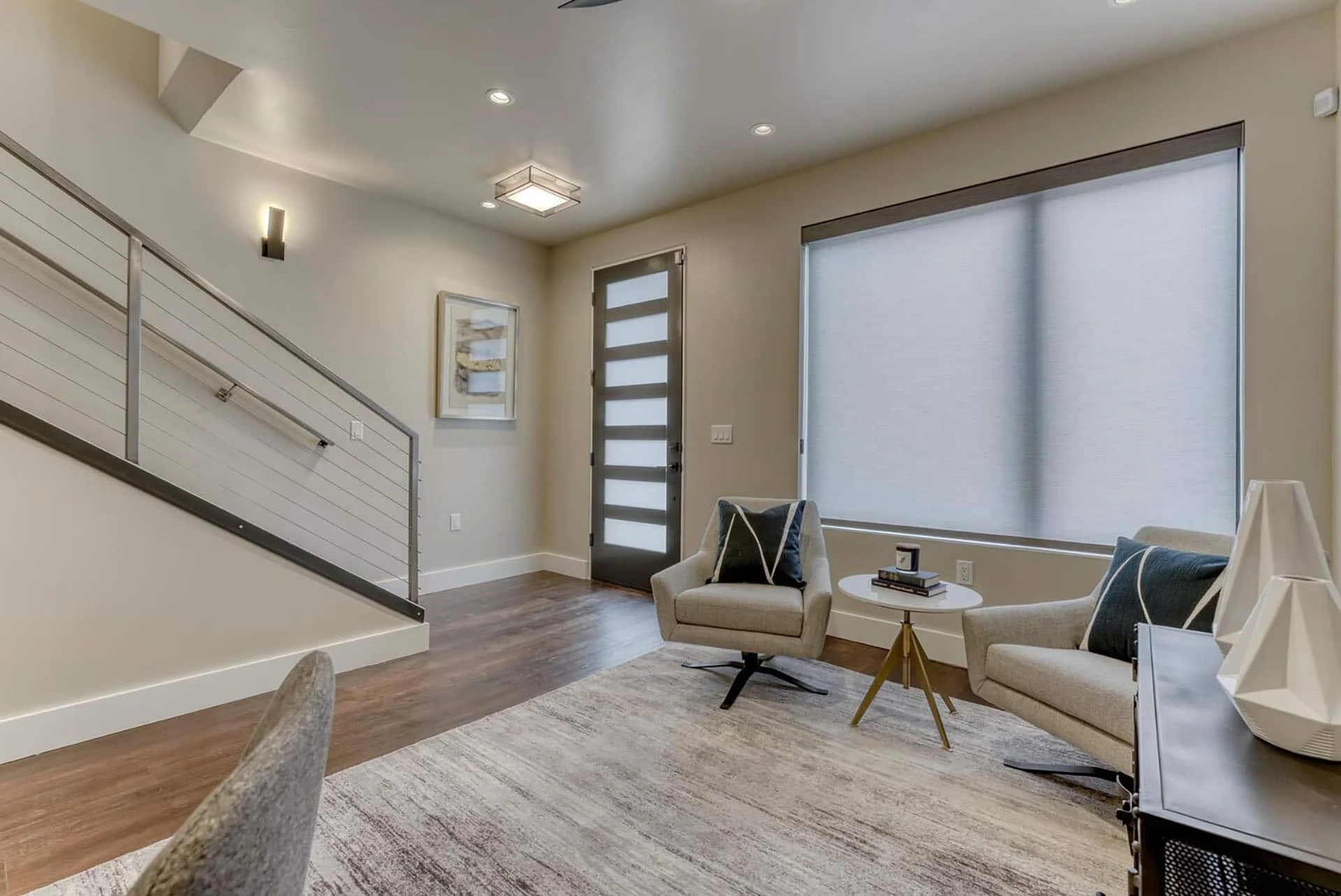 Living area beside the stair with a glass-panel front door
