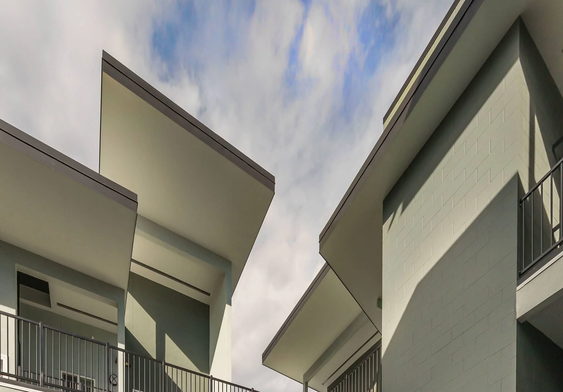 Upswept overhangs and sage green walls seen from below