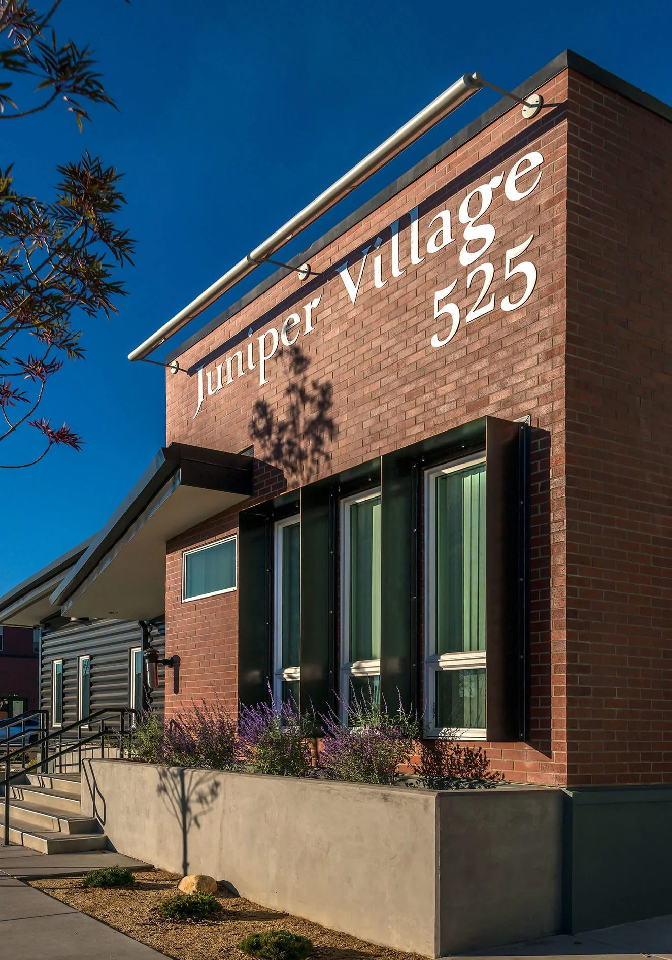 Brick community center with Juniper Village 525 lettering and tall windows