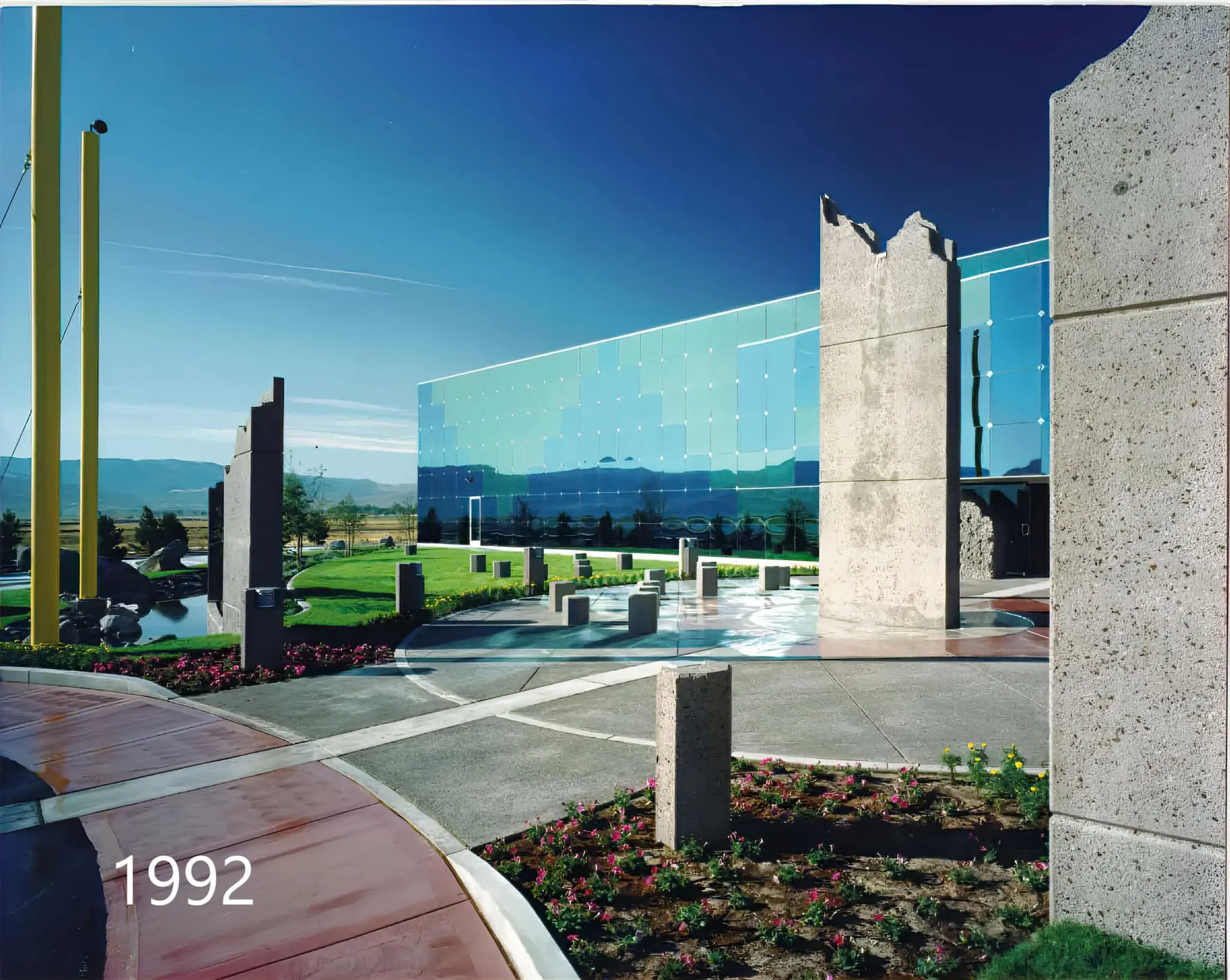 Concrete entry panel beside the glass facade and curving walkway, photographed in 1992