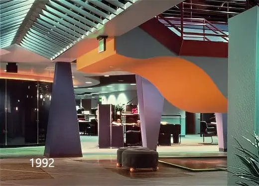 Open interior with an orange wave-shaped ceiling form and sculptural columns, photographed in 1992