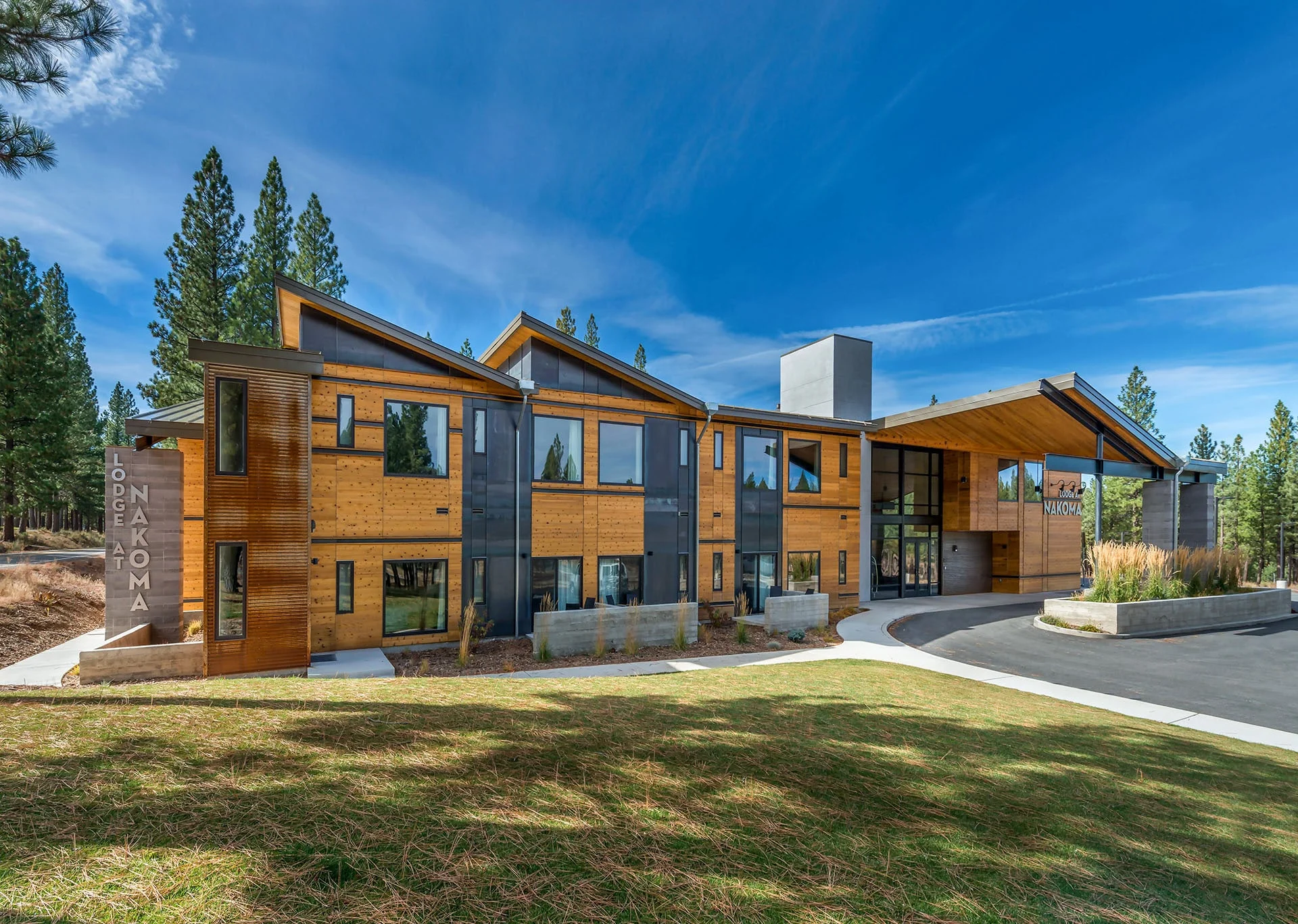 Lodge at Nakoma with wood and dark panel facades and upswept roofs above a green lawn