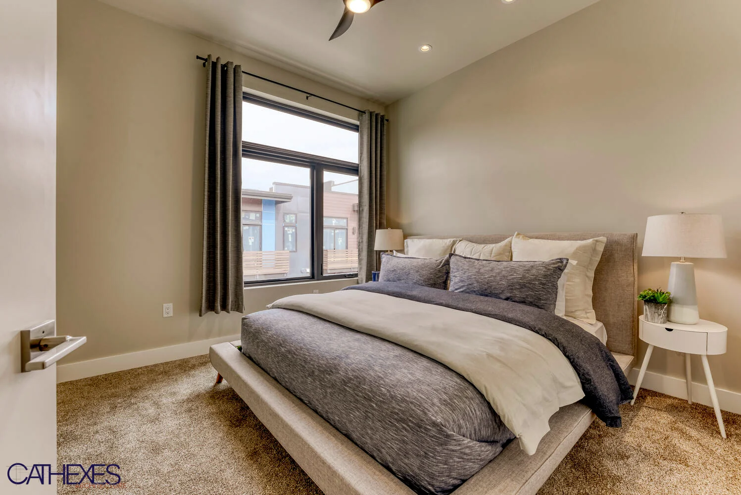 Bedroom with a low platform bed beneath a large window