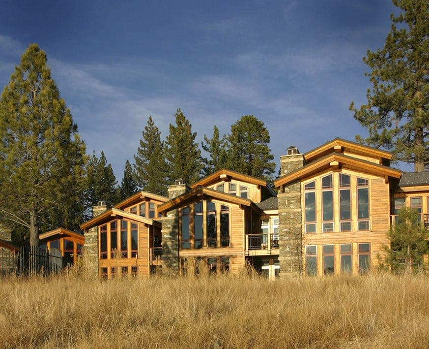 Tonopalo residences with stone chimneys and tall windows rising above golden meadow grass and pines