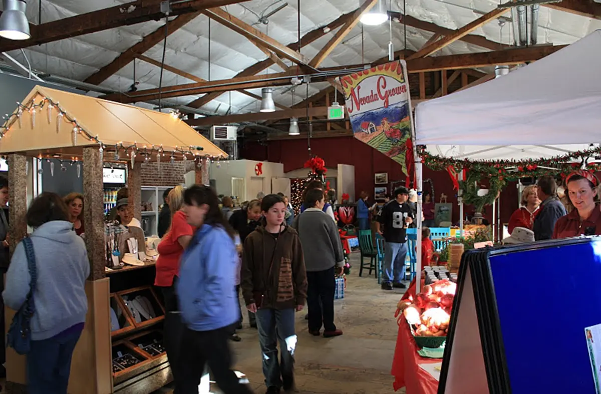 Shoppers browsing vendor stalls beneath exposed timber trusses inside the market hall